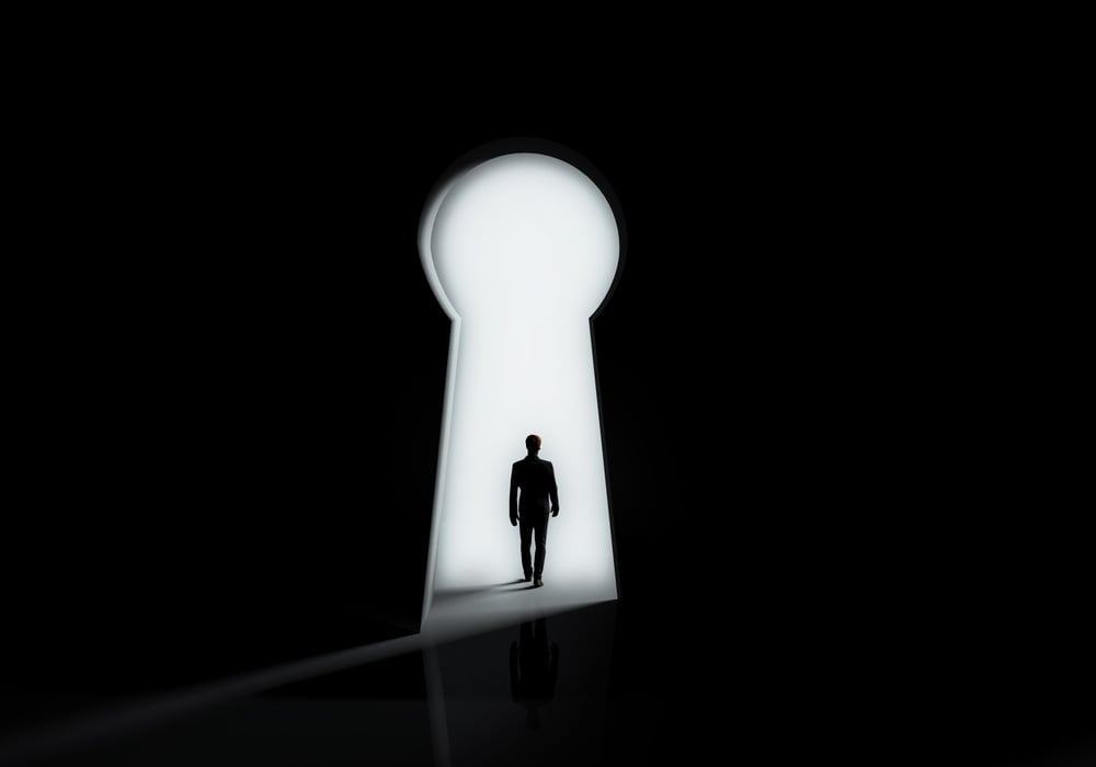 Businessman Silhouette Standing Front of Keyhole Door